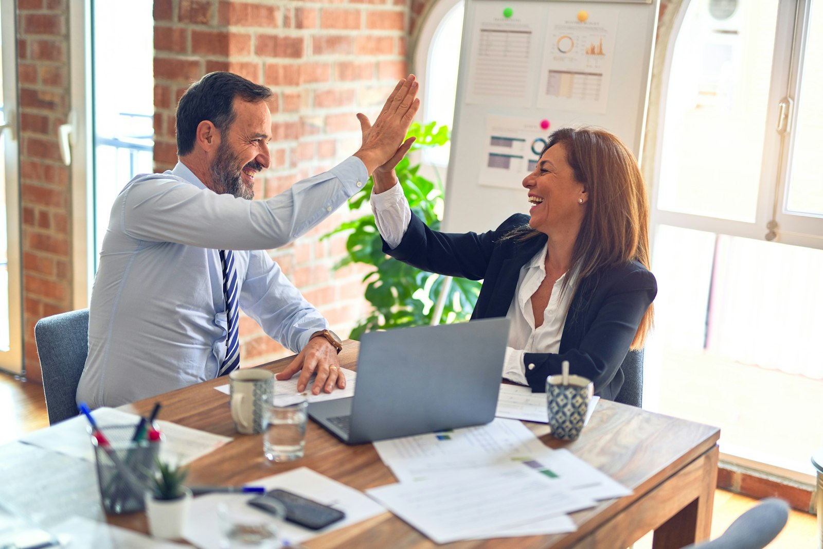 Consultor y cliente celebrando un proyecto entregado
